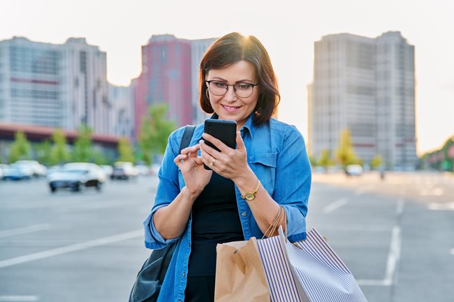 Woman who just went shopping looking at phone