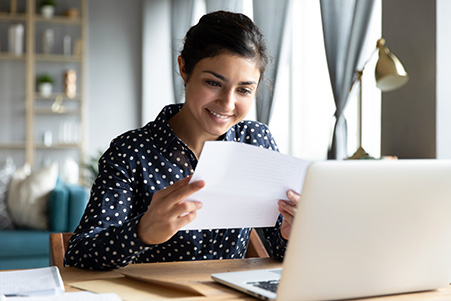 woman working on computer and reviewing documents