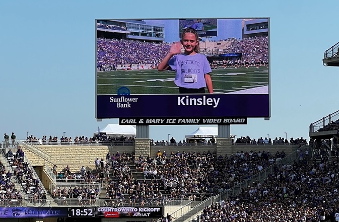 Kid on the big screen at a K-State football game for Sunflower Bank's Kick Off Kid