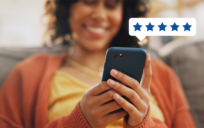 woman smiling and looking at her phone with 5 stars