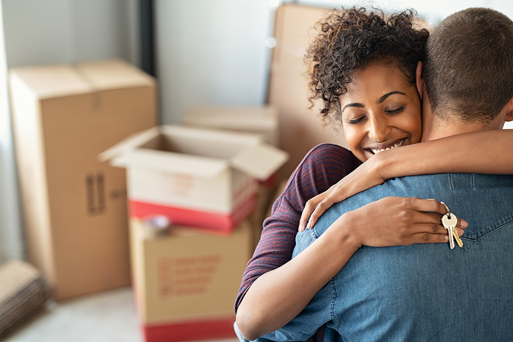 Woman hugging man in front of moving boxes