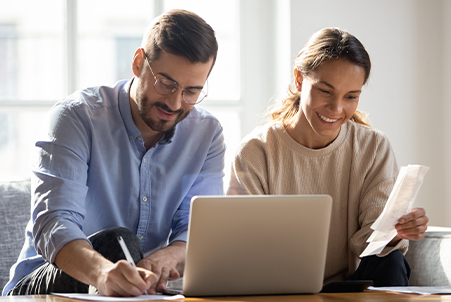 couple sitting looking at laptop