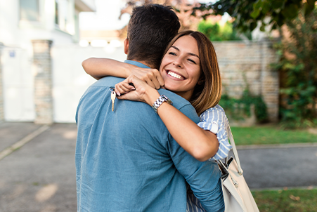 woman hugging man holding house key