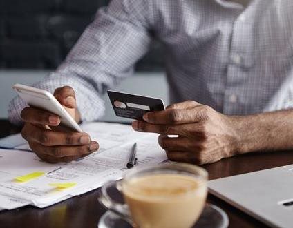 man holding phone and credit card for business