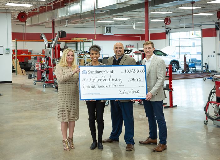 Four Workers Holding a Check