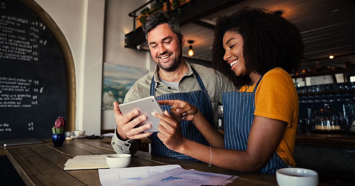 two employees looking at a tablet