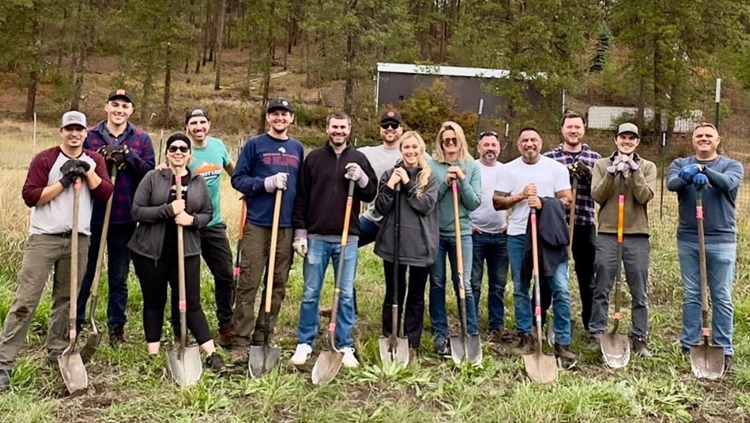 group of people volunteering outside holding shovels