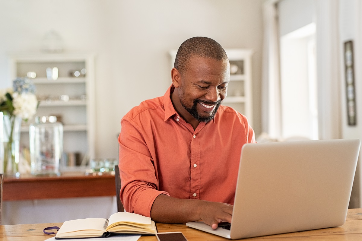 man using laptop smiling