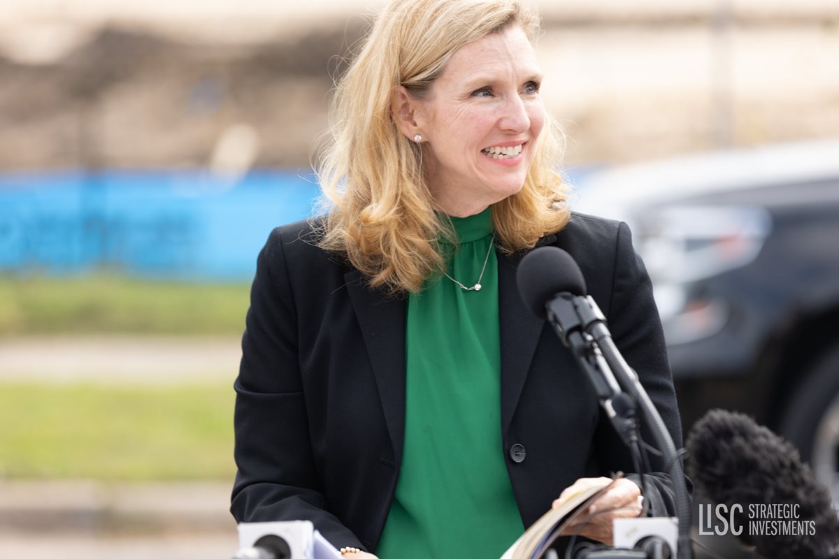 women in green and black speaking in microphone