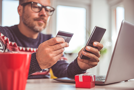 Man looking at card and phone