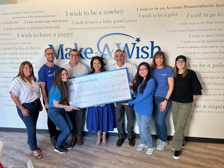 group of people holding a large Sunflower Bank check for Make-A-Wish