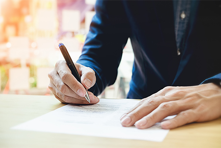 man writing on paper