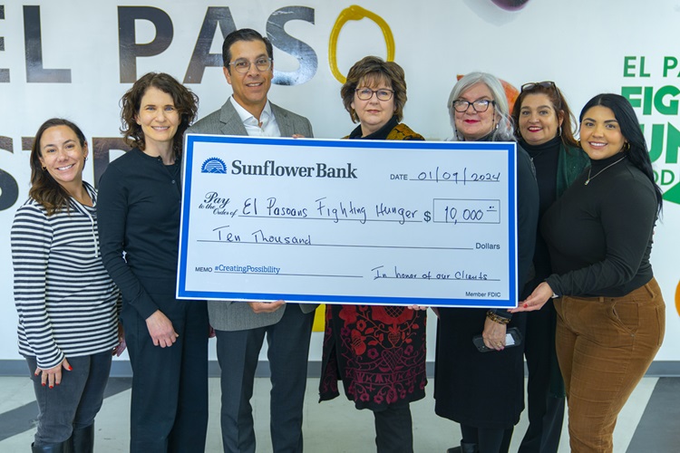 7 people holding a large donation check