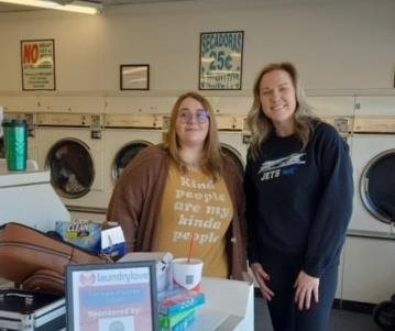 two women smiling in laundromat