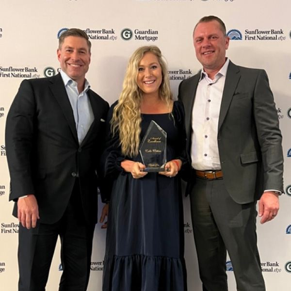 Callie, woman, being presented award with two male coworkers
