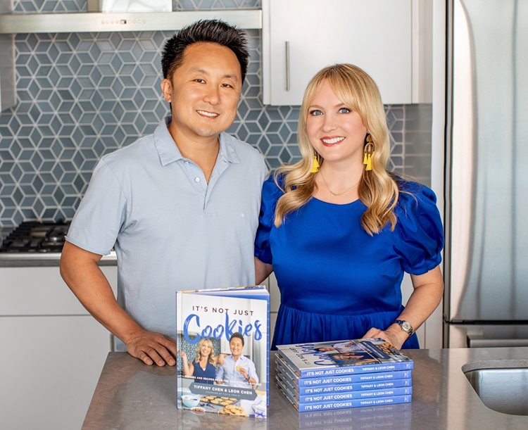 two individuals in a kitchen with a cookbook