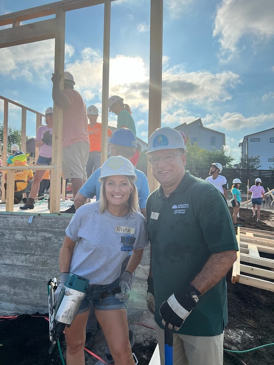 two people with hard hats volunteering at construction site